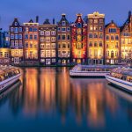 Damrak in Amsterdam tijdens het blauwe uurtje