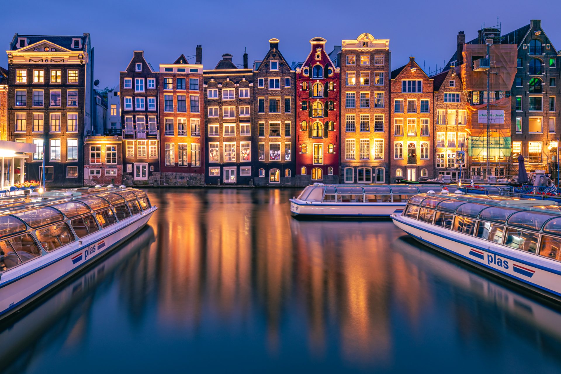 Damrak in Amsterdam tijdens het blauwe uurtje
